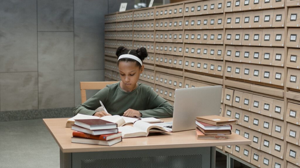 ChatGPT Quellen prüfen bei der Recherche mit Büchern und Laptop